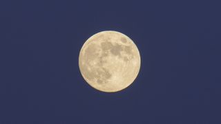 a bright full moon in a dark blue night sky