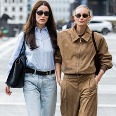 nnabel Rosendahl wears blue blouse, ripped denim jeans, black bag & Tine Andrea wears light brown zipper jacket, pants outside Gestuz during Copenhagen Fashion Week day three on August 06, 2025 in Copenhagen, Denmark. (Photo by Christian Vierig/Getty Images)