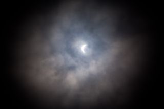 cloudy partial solar eclipse