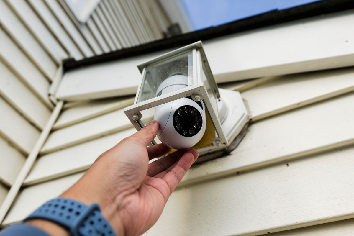 Symynelec security camera light bulb installed outdoors inside of light fixture.