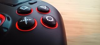 A black QRD Spark N5 PS4/5/PC controller sitting on a light wooden desk