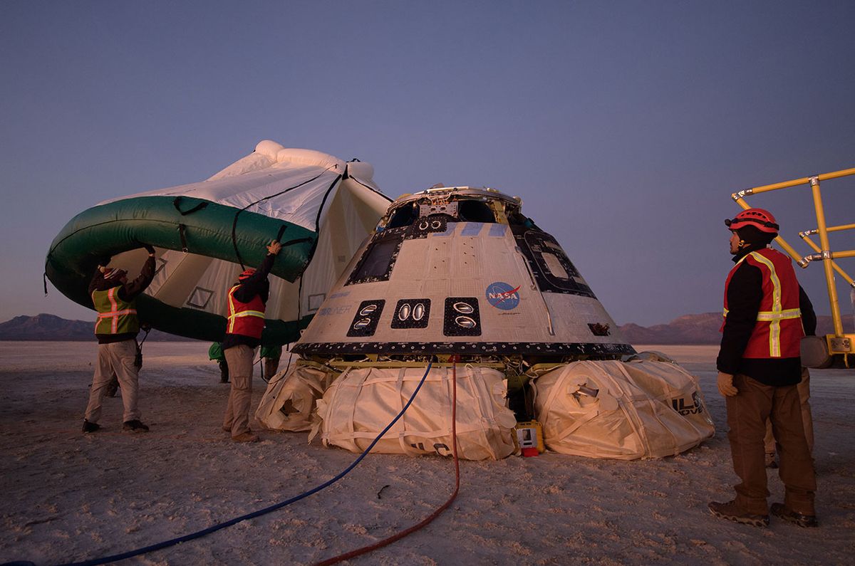 An environmental enclosure is put into position over the Boeing CST-100 Starliner spacecraft shortly after it landed in White Sands, New Mexico, on Sunday, Dec. 22, 2019. The capsule was named &quot;Calypso&quot; by NASA astronaut Suni Williams, who will command its first re-flight. 