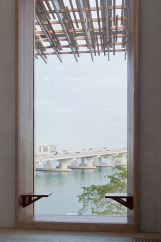 Looking through a bay window to a river and bridge.