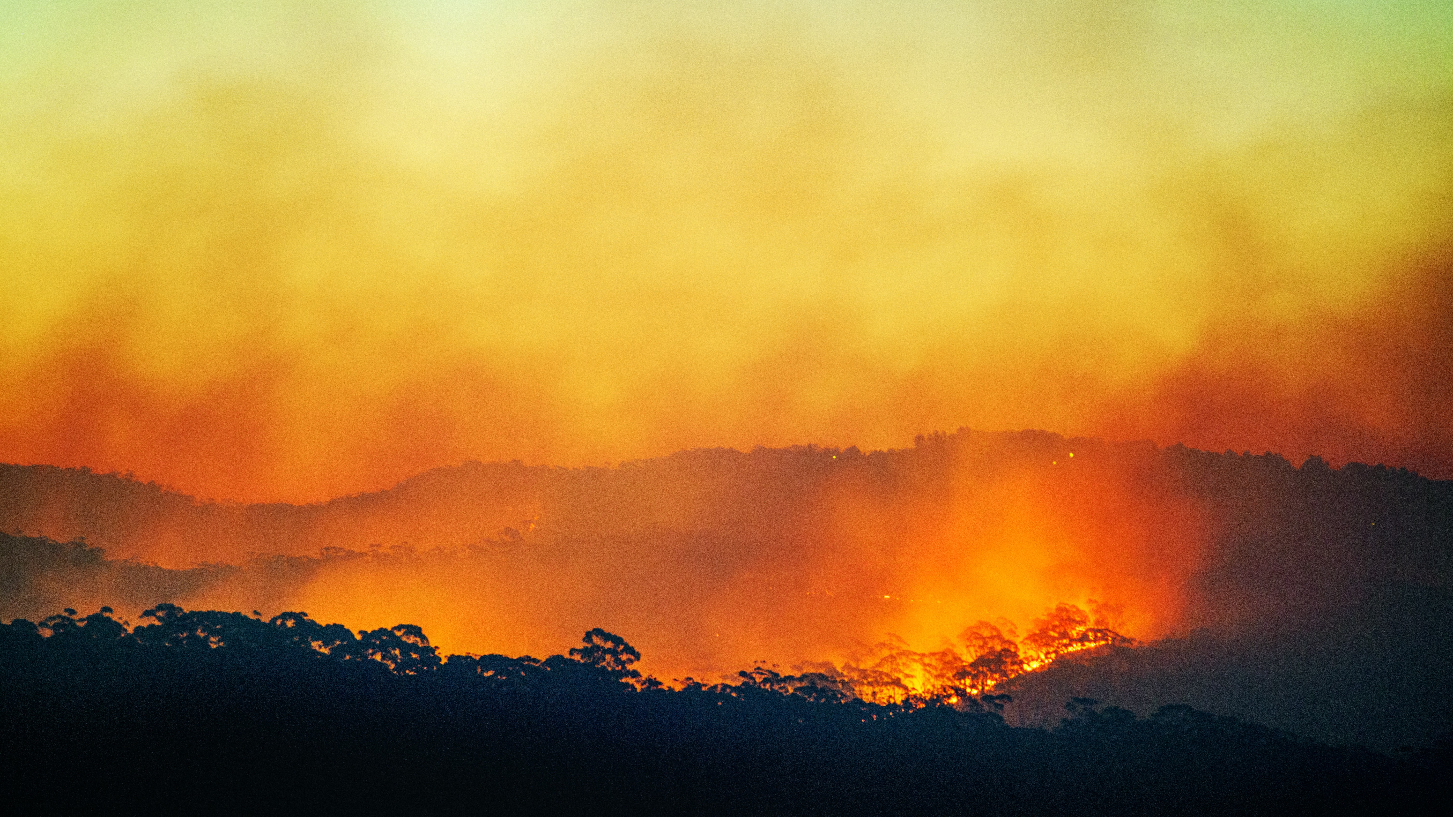 A photo of a wildfire burning at sunset in Australia. 