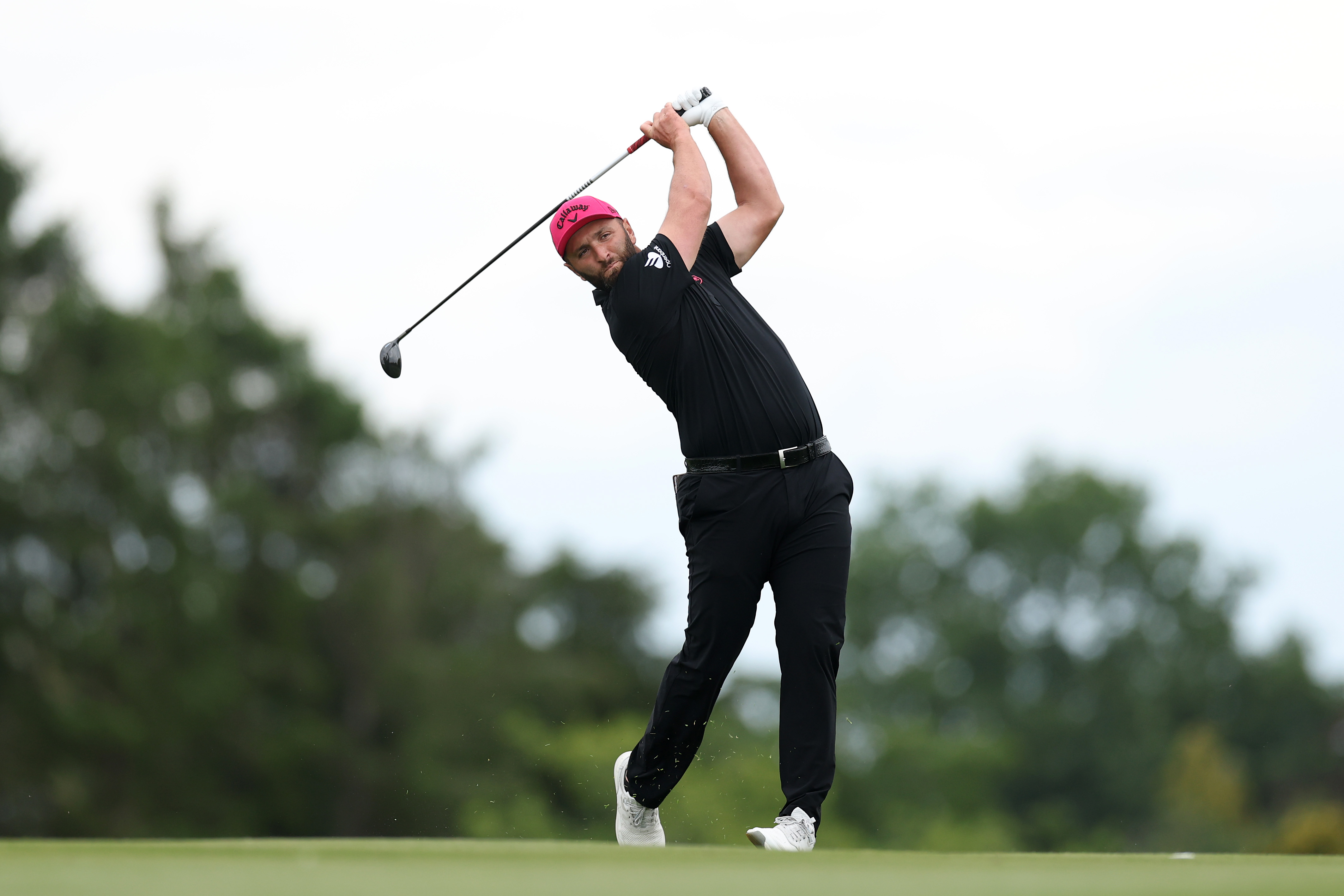 Jon Rahm hits a fairway wood