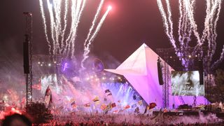 ireworks illuminate the sky while bands perform on the Pyramid Stage at the Glastonbury Festival