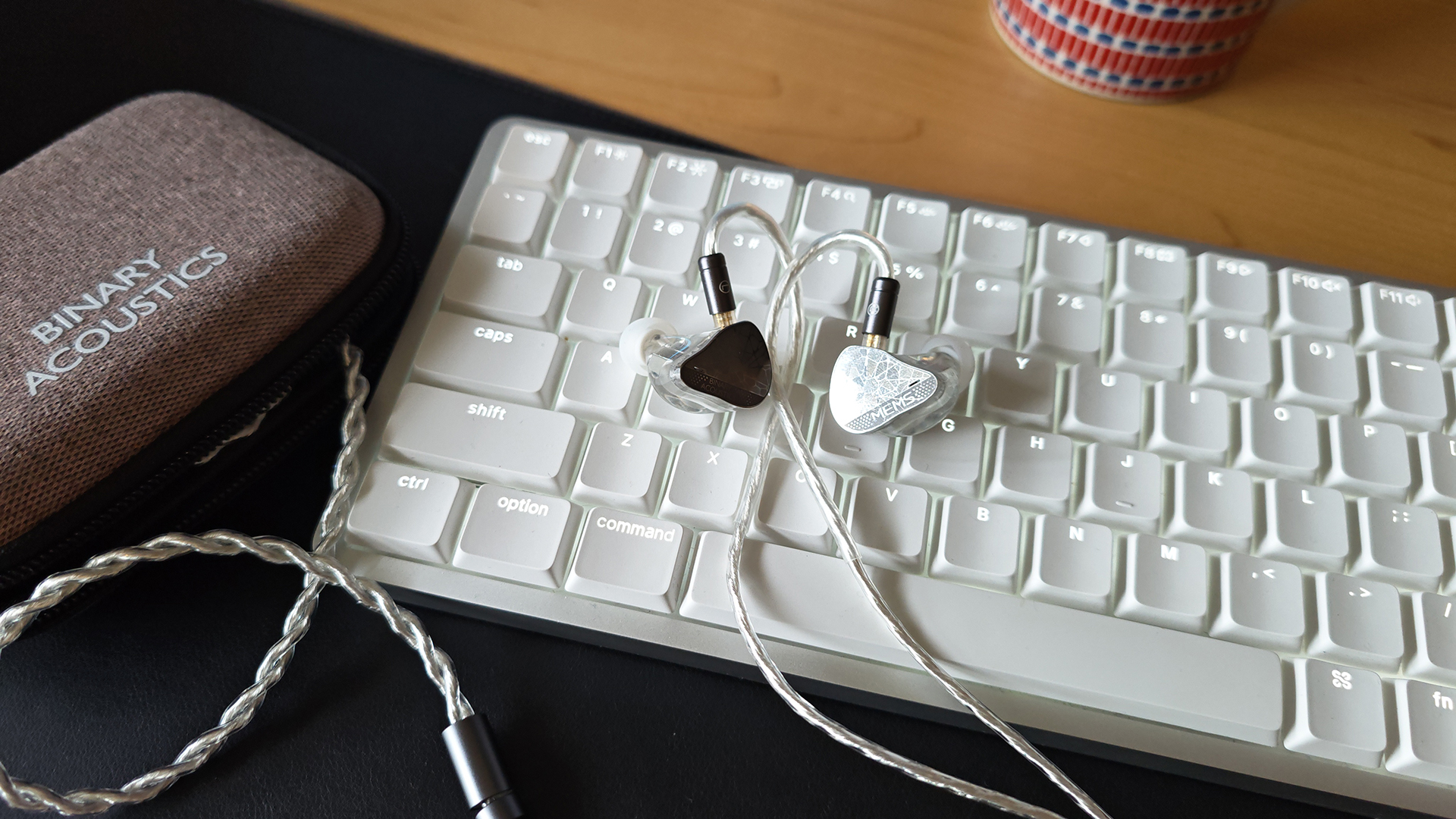 Two photos of the EP321 MEMS earphones, placed on a white keyboard.