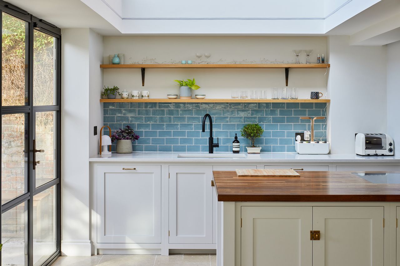 blue and white kitchen with large rooflight and black tap