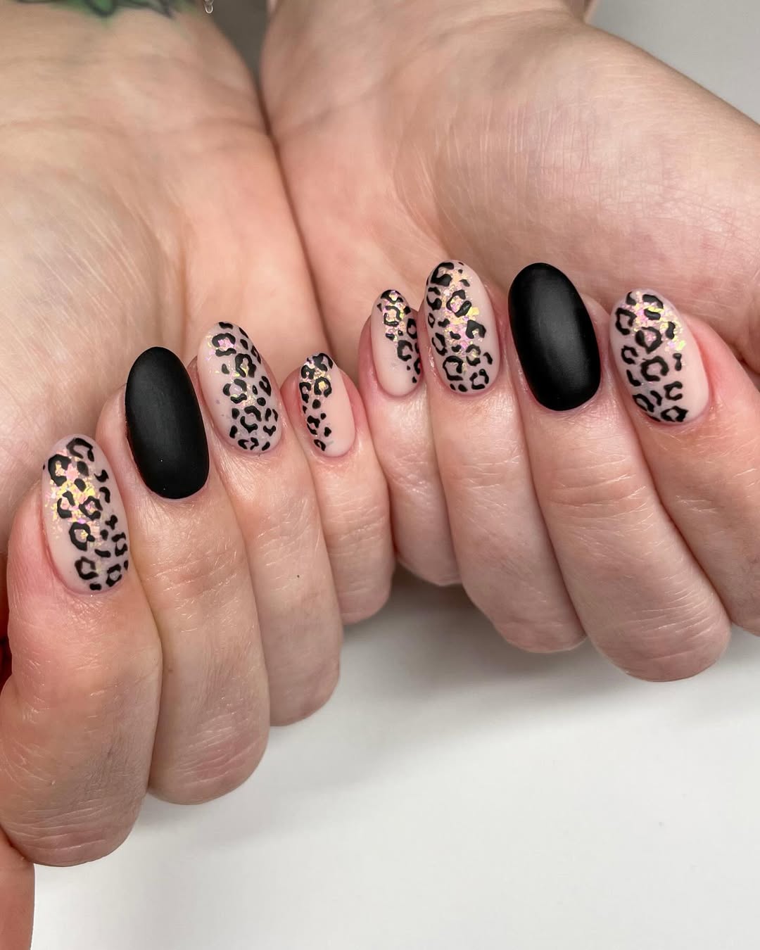leopard nails with a matte black accent nail