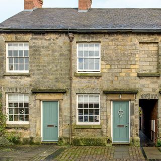 stone wall house with green doors