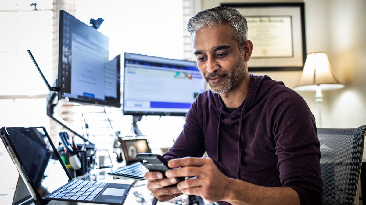 man working on phone at desk