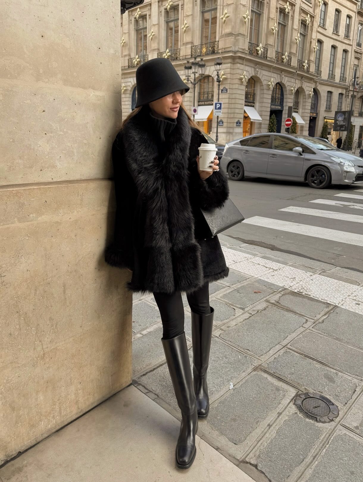 An image of @lovisabarkman wearing a fur-effect coat with leggings and knee-high flat boots.