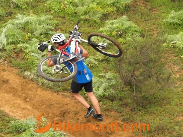 A racer carries his bike