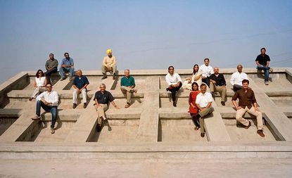 Indian architects sitting on a concrete structure.