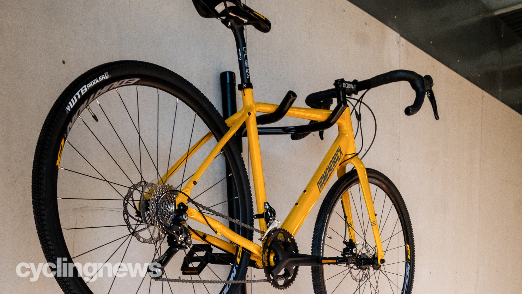 Saris Bunk 2-Bike Storage Stand with a yellow bike hanging from the top