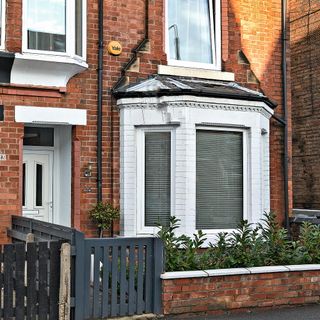 house with brick wall and wooden gate