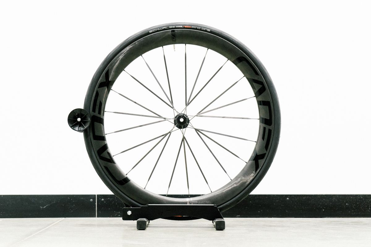 An aero road wheel stands against a white wall
