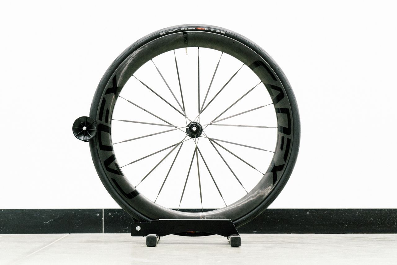 An aero road wheel stands against a white wall