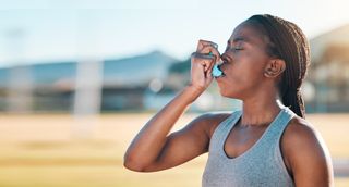 A woman using an asthma inhaler