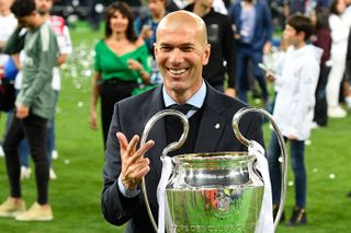 Real Madrid coach Zinedine Zidane celebrates with the trophy after winning the Champions League for a third year in a row in 2018.