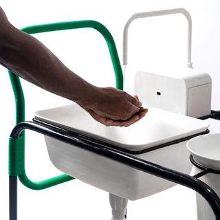 man washing hands on Nifemi Marcus-Bello portable handwashing station