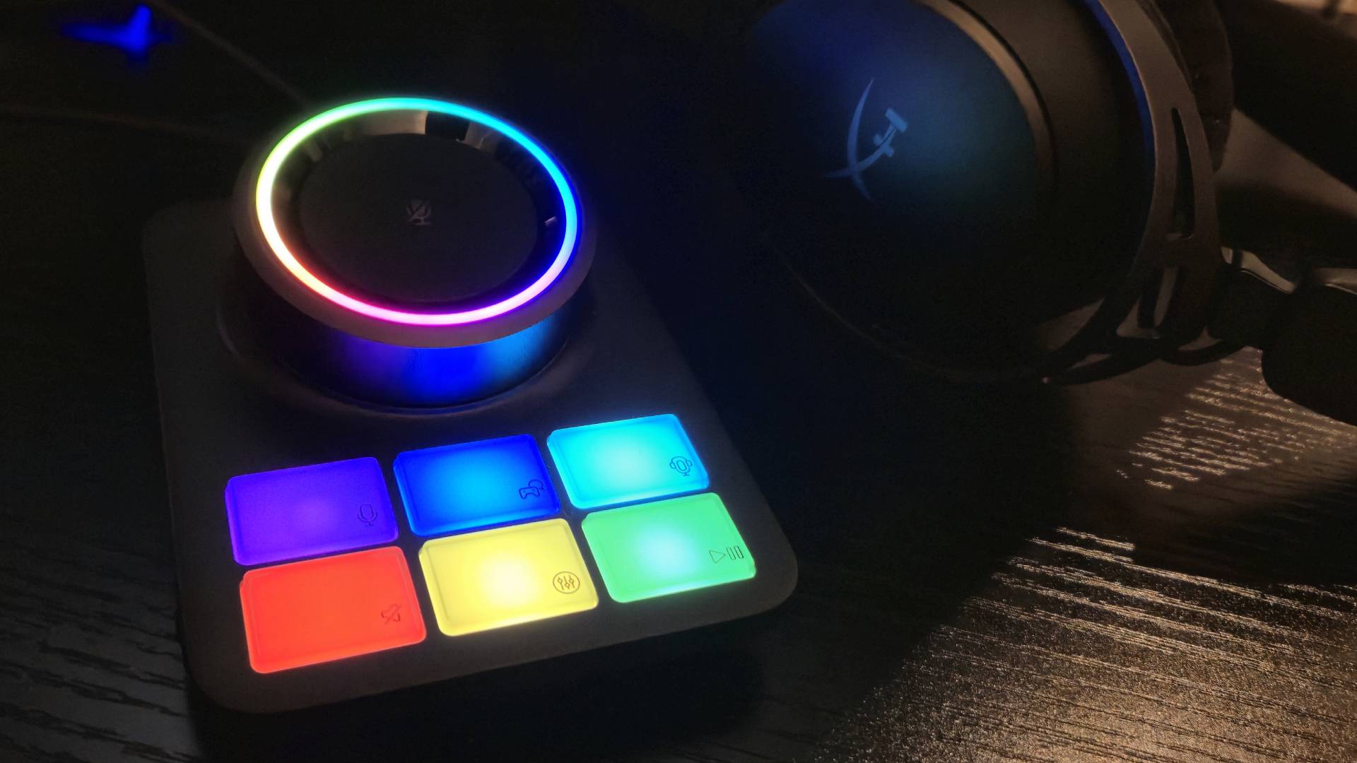 Photo of an RGB lit up base station. Its lights are glowing on the side of a wireless headset.