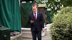 Former national security adviser Mike Waltz checks his phone