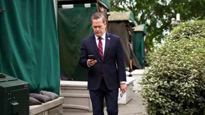 Former national security adviser Mike Waltz checks his phone