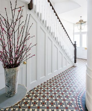 Victorian hallway tiles in grey, red, black and white with simple white painted walls