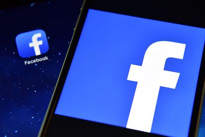 The Facebook app logo is displayed on an iPad next to a picture of the Facebook logo on an iPhone on August 3, 2016 in London, England.