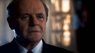 Anthony Hopkins stands with an eerie look on his face in Hannibal.