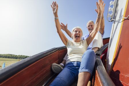 Older couple going down slide 