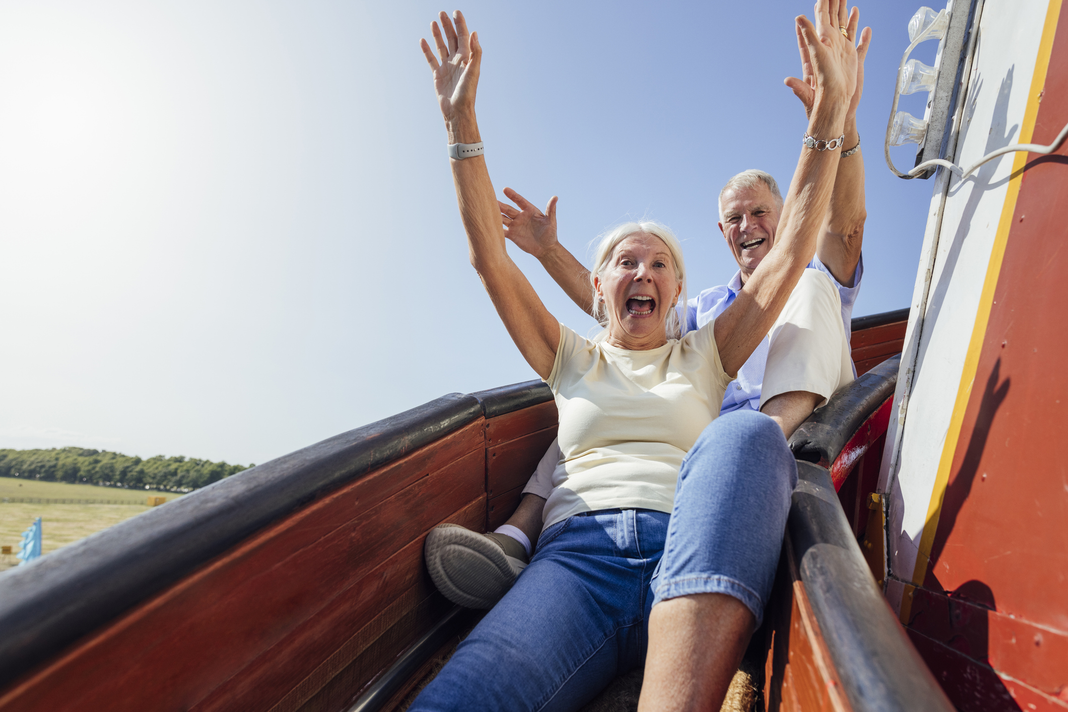 Older couple going down slide 