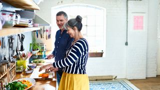 Mature couple preparing meal in stylish kitchen
