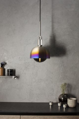 modern steel pendant hung against a grey wall