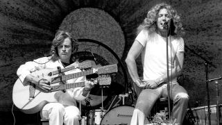 Singer Robert Plant and John Paul Jones (playing a triple-necked guitar) of the rock band "Led Zeppelin" perform onstage at Alameda County Coliseum in Oakland, California.