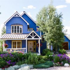 A beautiful flower garden in the front yard of a blue house