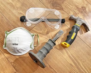 DIY safety goggles and dust mask next to hammer and chisel