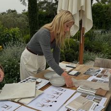 Gwyneth Paltrow wears a grey jumper with white trousers.