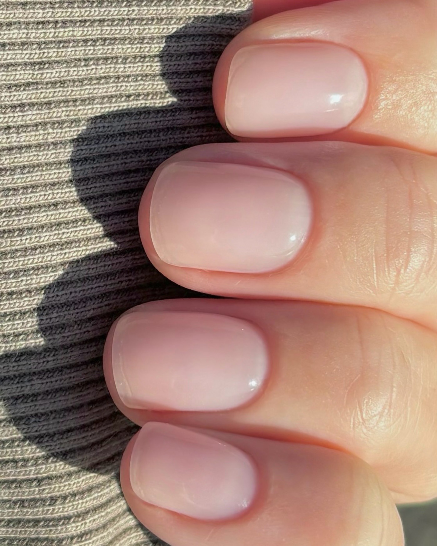 A short, slightly rounded sheer manicure look