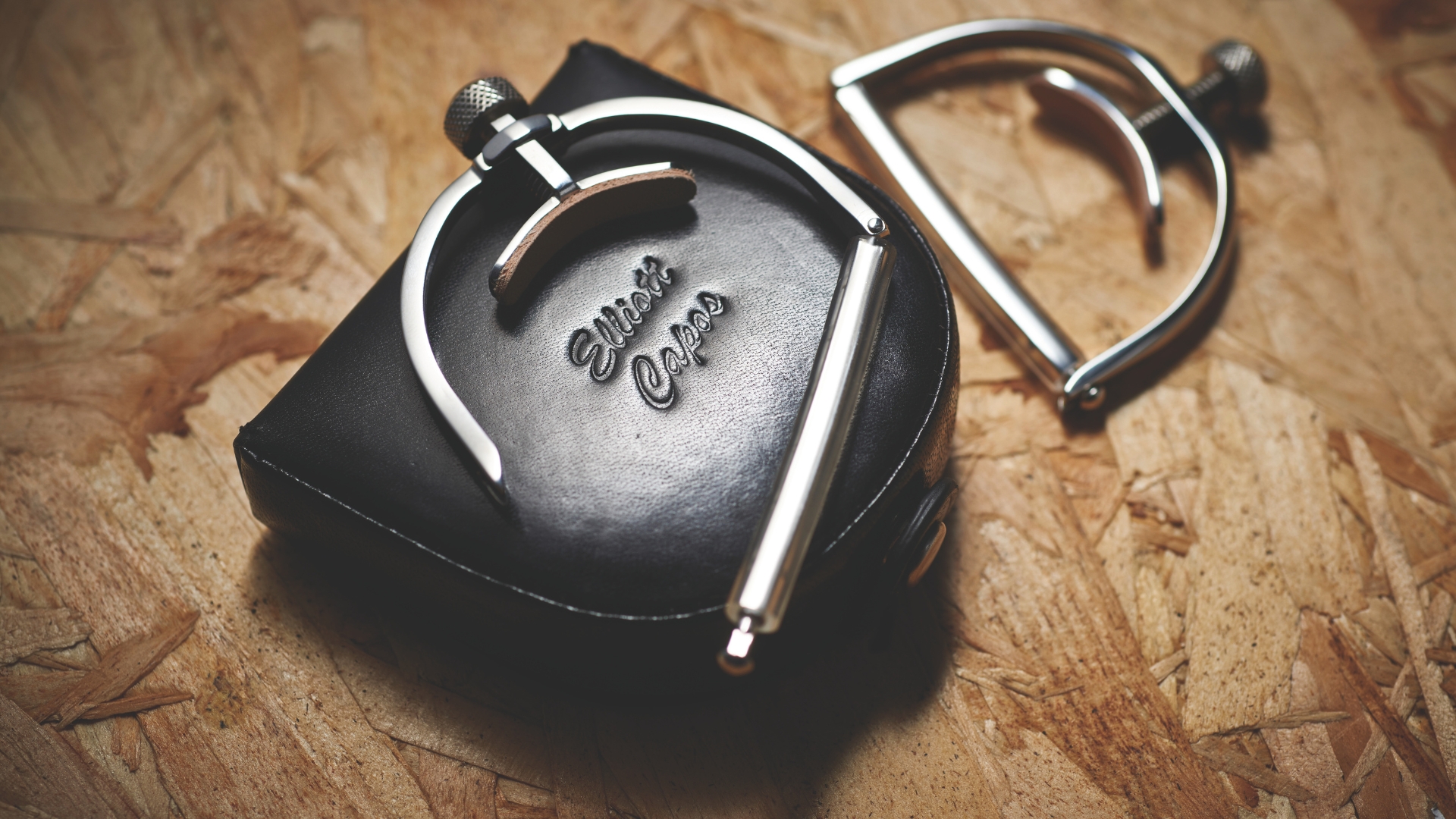 A guitar capo on top of a leather case
