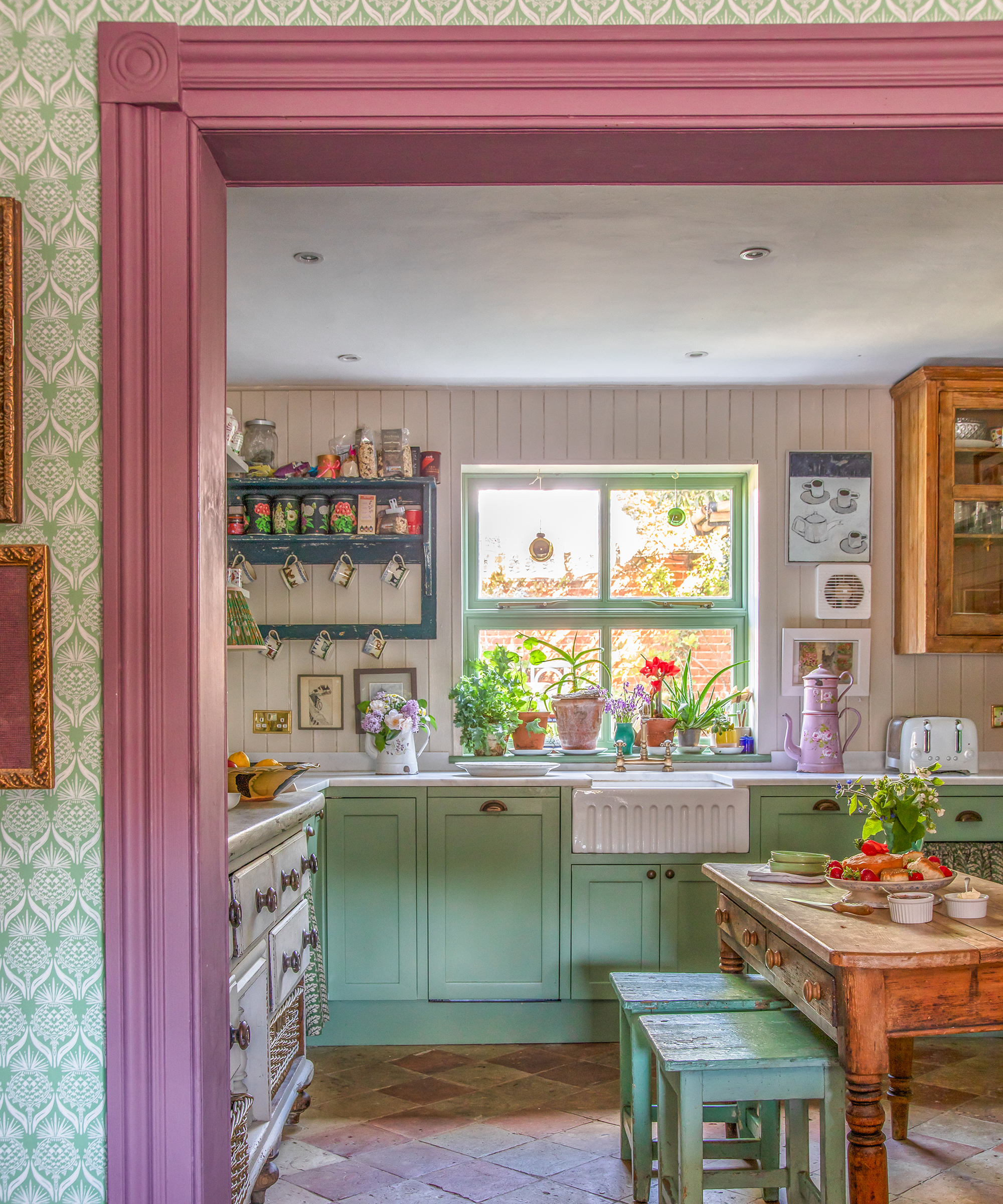 vintage style kitchen with green painted cabinets, farmhouse table and open shelves