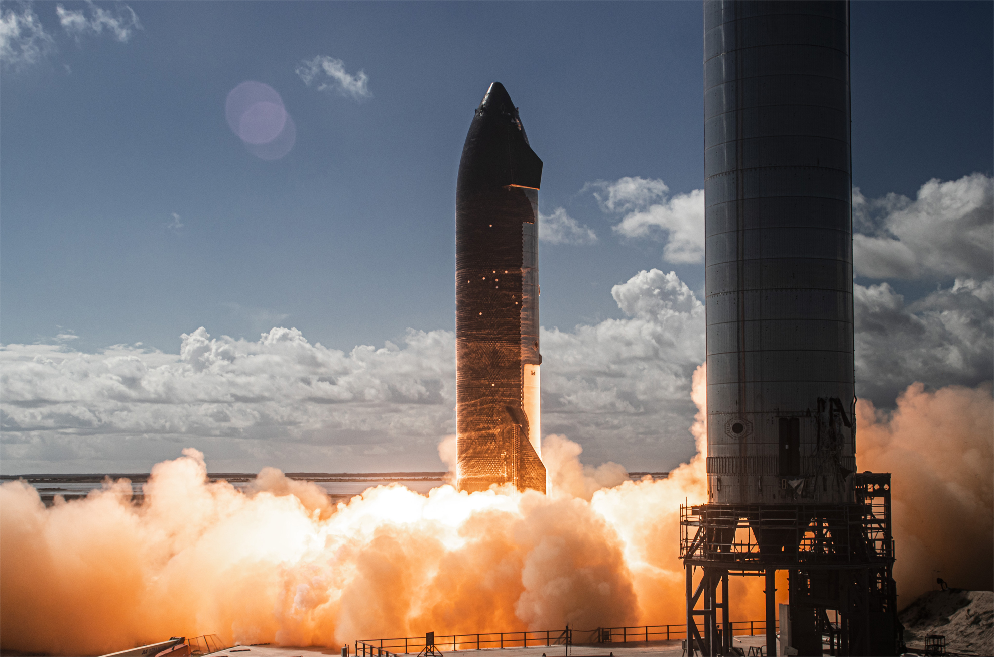 This SpaceX photo shows the first test-fire of six Raptor engines on the company's Starship SN20 rocket prototype on Nov. 12, 2021 at the Starbase facility in near Boca Chica Village in South Texas. A Starship Super Heavy booster stands at right.