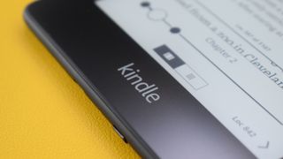 Close up of a Kindle eReader on a yellow leather surface.