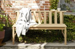 A pale wood garden bench with Scandinavian feel