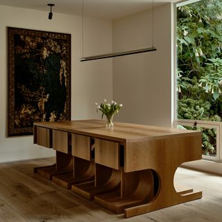 A dining room with custom made table and wall tapestry