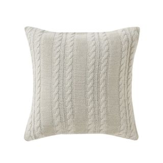 A beige knitted throw pillow