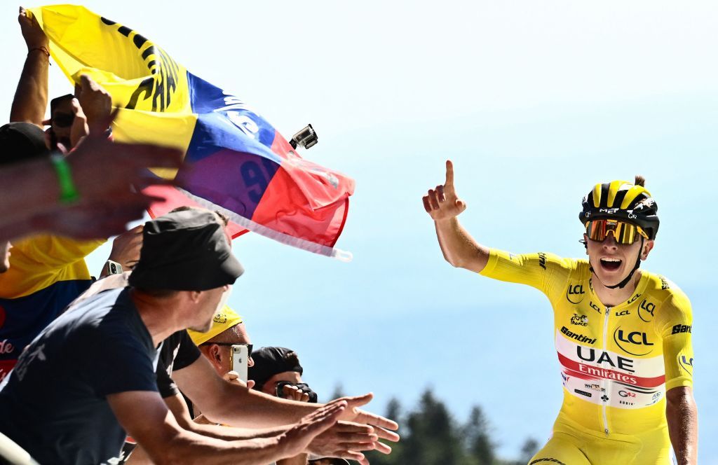 TOPSHOT UAE Team Emirates teams Slovenian rider Tadej Pogacar wearing the overall leaders yellow jersey R celebrates as cycles past the finish line to win the 7th stage of the 109th edition of the Tour de France cycling race 1763 km between Tomblaine and La Super Planche des Belles Filles in eastern France on July 8 2022 Photo by Marco BERTORELLO AFP Photo by MARCO BERTORELLOAFP via Getty Images