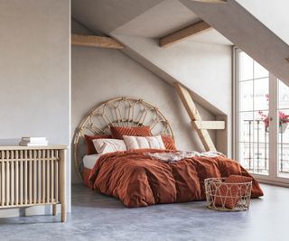 wicker framed bed with rust bedding in loft bedroom
