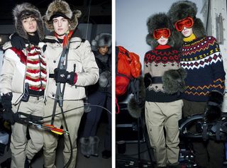 Models wearing winter ski clothing in beige and red with orange ski goggles